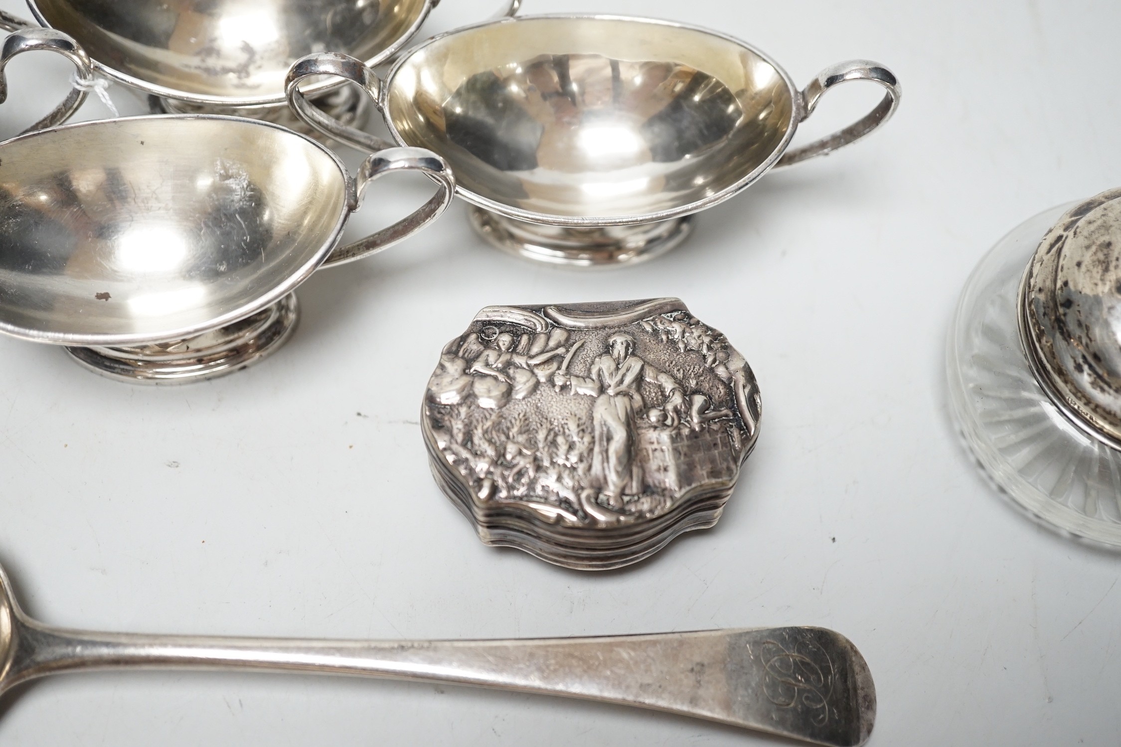A set of four Edwardian silver two handled boat shaped salts, London, 1901, width 10.5cm, two 18th century silver base mark table spoons, a continental white metal snuff box and a silver mounted glass tidy.